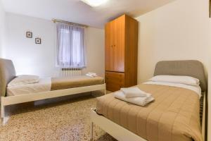 um quarto com 2 camas, um armário e uma janela em Mimosa Apartment em Veneza
