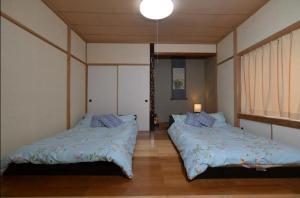 伊達市にあるSTAY IN OTAKIのベッドルーム(ベッド2台、照明付)