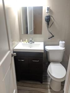 uma casa de banho com um WC branco e um lavatório. em A-1 Budget Motel em Homestead