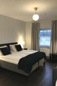 - une chambre avec un grand lit et une fenêtre dans l'établissement Rasta Värnamo, à Värnamo