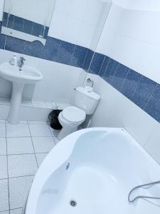 a bathroom with a white toilet and a sink at Hotel Restaurant Enigma Plopeni in Plopeni