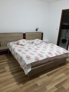 a bed in a bedroom with a wooden floor at Hotel Restaurant Enigma Plopeni in Plopeni