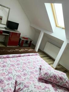 Un dormitorio con una cama con una manta rosa. en Hotel Restaurant Enigma Plopeni, en Plopeni