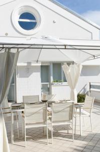 a patio with a table and chairs and an umbrella at Dante 124 | Appartamenti a Riccione in Riccione