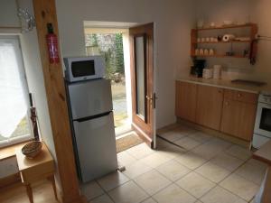 a kitchen with a refrigerator and a microwave at Ker Maniok in Paule
