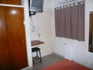 a small room with a television and a door at Hotel Cosme in Buenos Aires