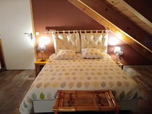 a bedroom with a large bed with a wooden floor at La Grange de l'Ardeyrol in Saint-Clément