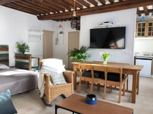a living room with a bed and a television on a wall at L'authentique in Honfleur
