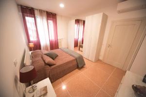 een kleine slaapkamer met een bed en een aantal ramen bij Saffi 15 Apartments in Bologna