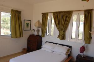 a bedroom with a bed and two windows at Villa Kitrini in Kyparissia