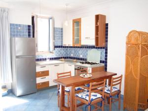 a kitchen with a wooden table and a refrigerator at Le Case dei Pescatori - La Suite in Ponza