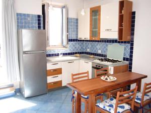 a kitchen with a wooden table and a refrigerator at Le Case dei Pescatori - La Suite in Ponza +3 photos