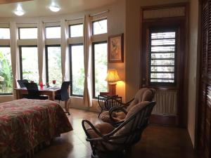 - une chambre avec des chaises, une table et des fenêtres dans l'établissement Villa Cayo, à San Ignacio
