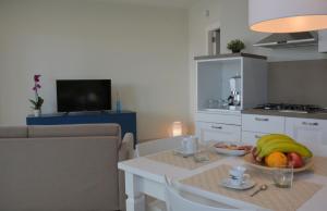 a kitchen and living room with a table with fruit on it at Vilu Suite Mare in Polignano a Mare