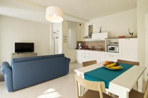 a kitchen and dining room with a table and a blue couch at Vilu Suite Mare in Polignano a Mare