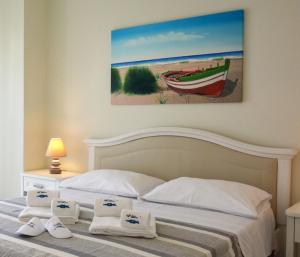 a bedroom with a bed with a painting on the wall at Vilu Suite Mare in Polignano a Mare