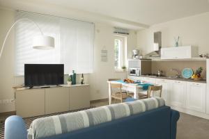 a living room with a blue couch and a kitchen at Vilu Suite Mare in Polignano a Mare