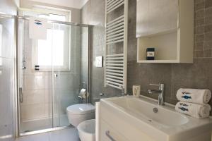 a bathroom with a sink and a toilet and a shower at Vilu Suite Mare in Polignano a Mare