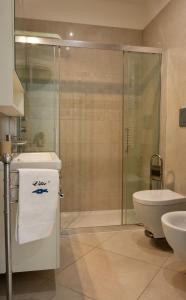 a bathroom with a shower and a sink and a toilet at Vilu Suite Mare in Polignano a Mare