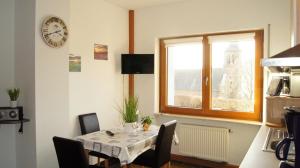 a dining room with a table with chairs and a clock at Die Ferienwohnungen Dominik , Fill in Horath