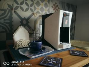 a microwave sitting on top of a table with a cup at Dimora Fraula Guest House in Agrigento