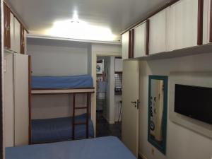 a small room with a bunk bed and a tv at BRISTOL PARQUE AREIA PRETA in Guarapari