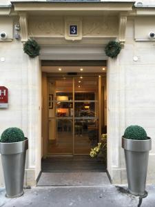 ein Gebäude mit zwei großen Töpfen davor in der Unterkunft Hôtel Mayet in Paris