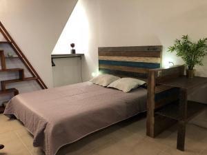 a bedroom with a large bed with a wooden headboard at L'authentique in Honfleur