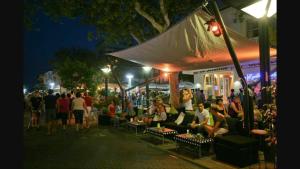 una folla di persone sedute sotto una tenda in una strada di notte di Suite Apartment Exclusive a Bellaria-Igea Marina Altre 89 foto