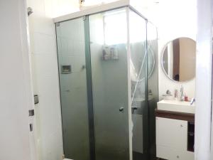 a shower with a glass door in a bathroom at APTº EM OLINDA CASA CAIADA in Olinda
