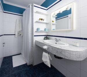 bagno bianco con lavandino e specchio di Apartamento Vista Farallón a Gáldar