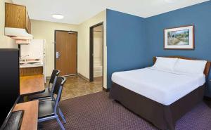 Habitación de hotel con cama y escritorio con ordenador en WoodSpring Suites Holland - Grand Rapids en Holland