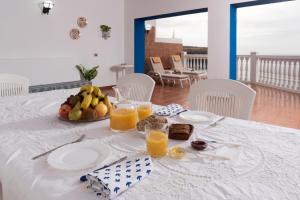 a table with a plate of fruit and orange juice at Apartamento Vista Farallón in Gáldar