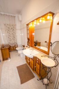Un baño con lavabo, espejo e inodoro. en Hello Rose - Appartamento intero, en Roma