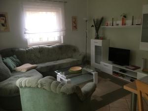 ein Wohnzimmer mit einem Sofa und einem TV in der Unterkunft Ferienhaus Daul in Wandlitz