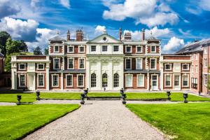 a large house with a grass yard in front of it at Hawkstone Hall Hotel & Gardens in Shrewsbury