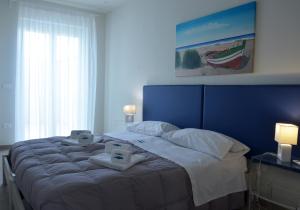 a bedroom with a large bed with two monitors on it at Vilu Suite Mare in Polignano a Mare