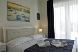 a bedroom with a bed with two towels on it at Vilu Suite Mare in Polignano a Mare