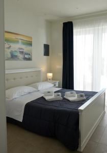 a bedroom with a large bed with two towels on it at Vilu Suite Mare in Polignano a Mare