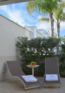 two chairs and a table on a patio at Vilu Suite Mare in Polignano a Mare