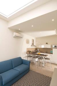 a living room with a blue couch and a kitchen at Vilu Suite Mare in Polignano a Mare