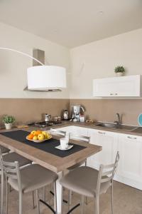 a kitchen with a table with a plate of fruit on it at Vilu Suite Mare in Polignano a Mare