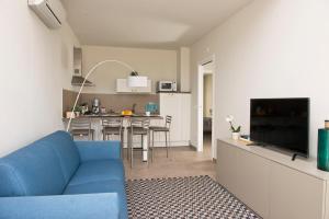 a living room with a blue couch and a kitchen at Vilu Suite Mare in Polignano a Mare