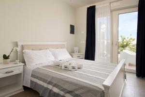 a white bedroom with a bed with two towels on it at Vilu Suite Mare in Polignano a Mare