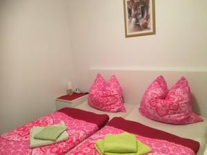 1 Schlafzimmer mit 2 Betten und rosa Kissen in der Unterkunft Ferienhaus Daul in Wandlitz