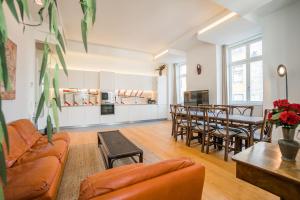 uma sala de estar com um sofá, uma mesa e cadeiras em Spacious & Bright Apartment in Cais Sodre em Lisboa