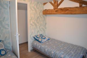 a bedroom with a bed with a pillow on it at Logement Vendée in Saligny