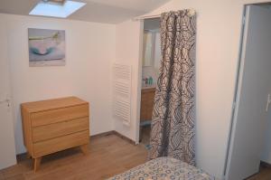 a bedroom with a bed and a dresser and a window at Logement Vendée in Saligny