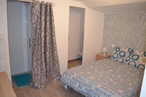 1 dormitorio con cama y cortina en Logement Vendée, en Saligny