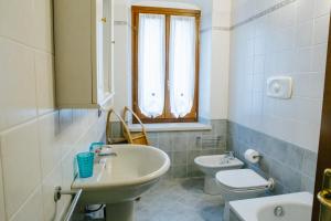 bagno con lavandino, servizi igienici e finestra di B&B Corte Dal Colle a Caldiero